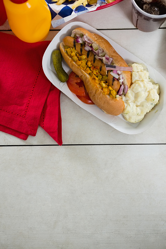 Close-up of American flag and hot dog on wooden table