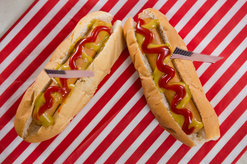 Close-up of American flag and hot dogs on wooden table