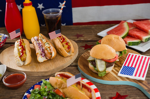 Close-up of American flag and hot dogs on wooden table