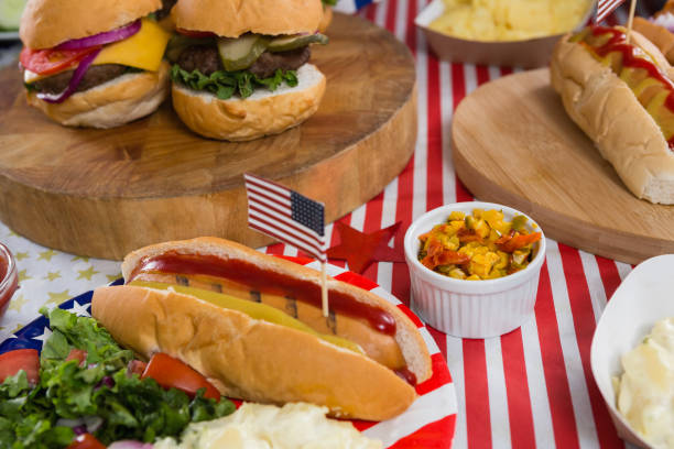 Burgers and hot dogs on wooden table with 4th july theme Close-up of burgers and hot dogs on wooden table with 4th july theme 70s theme stock pictures, royalty-free photos & images