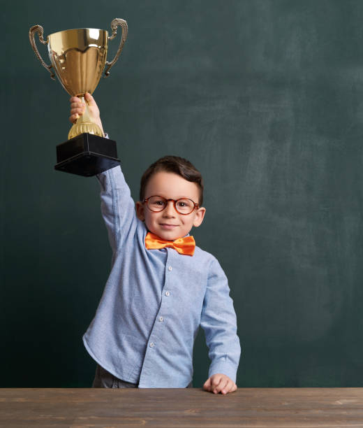 istock Cute child raising a golden trophy 801160806