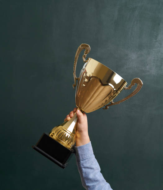 Child raising a golden trophy