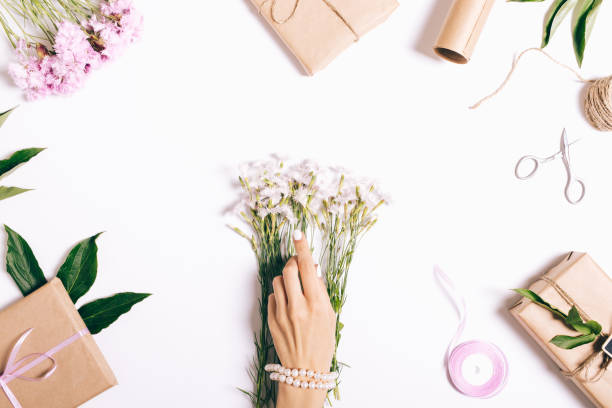 istock Female hands with a manicure make decorations for the holiday on a white table 801173184