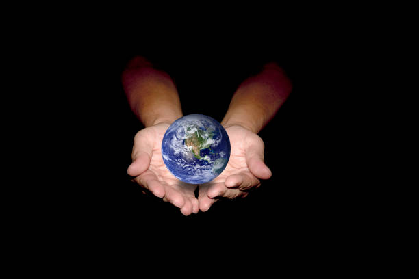 Blue earth in human hands isolated on black background. Elements of this image furnished by NASA.