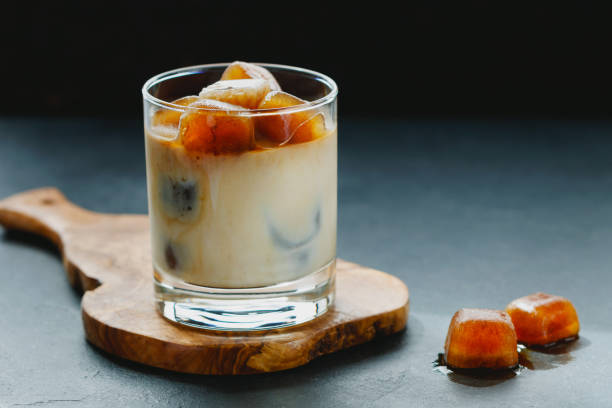 istock Iced coffee with milk on a wooden board on a black table. 801187348