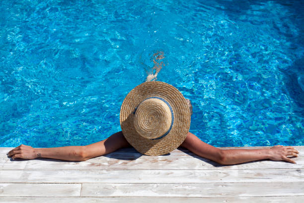 istock Woman in hat relaxing at pool 801187790