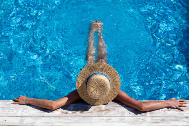 istock Woman in hat relaxing at pool 801187806