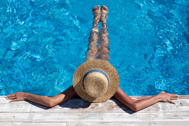 istock Woman in hat relaxing at pool 801187808