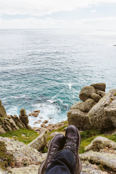 istock POV of man's walking boots, resting on Clifftop above Cornish Coast. 801224552