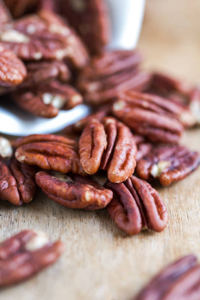 istock Raw Pecan in a white bowl on wooden board 801227948
