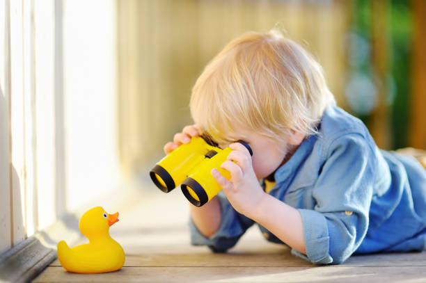 bambino carino che gioca con anatra di gomma e binocolo di plastica all'aperto - rubber duck foto e immagini stock