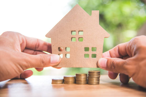 istock stack coins and house wood model with blur background, financial concept 801264062