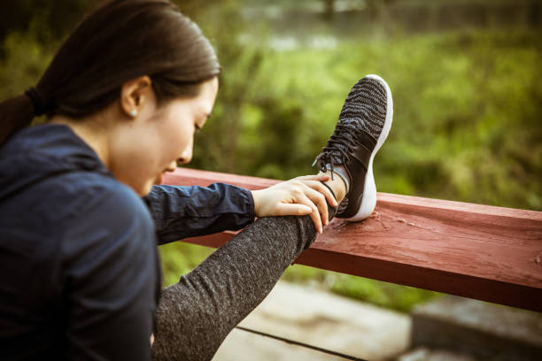 woman stretching legs with railing - railing beautiful human leg people imagens e fotografias de stock