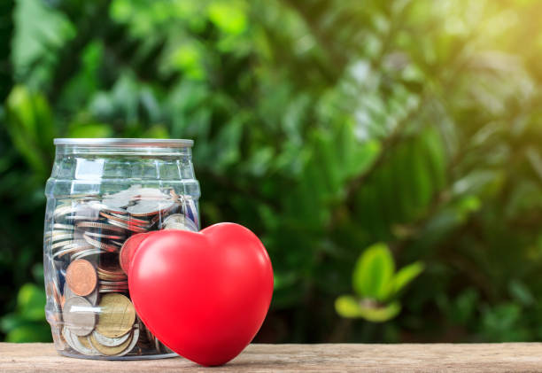 istock coins in bottle and red heart on table and nuture background 801284242