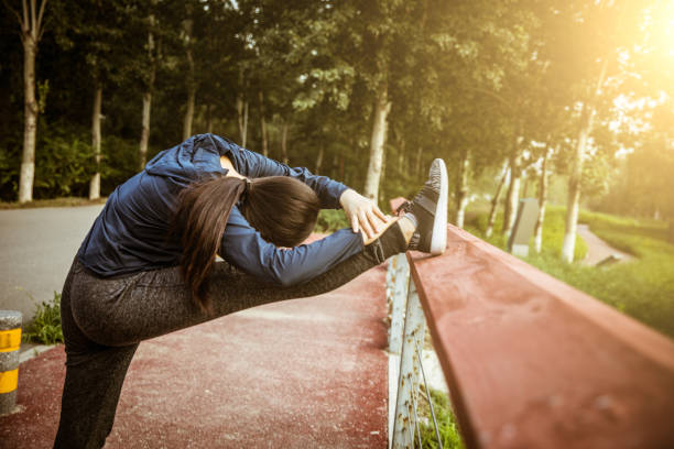 женщина растяжения ноги с railing - railing beautiful human leg people стоковые фото и изображения