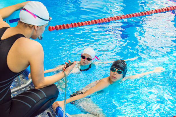 istock The instructor in the pool with a stopwatch marks the time at the start 801297414
