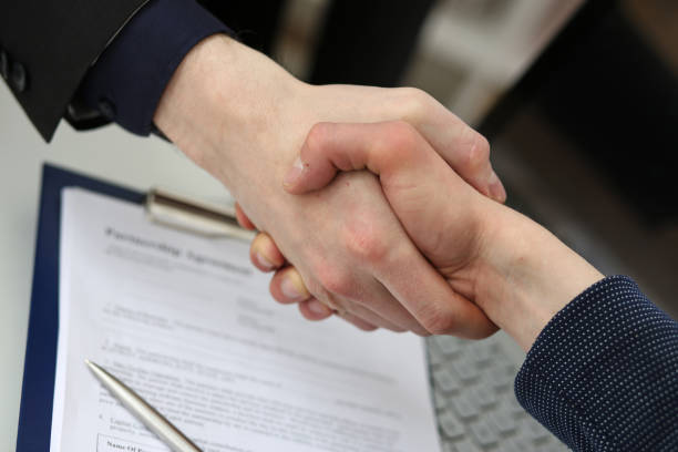 istock Two businessman shake hands as hello in office closeup 801300238