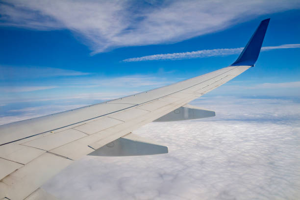 istock Airplane wing on the sky and over sea with clouds 801300266