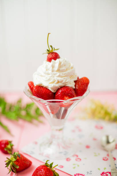 strawberries and cream on a wooden table