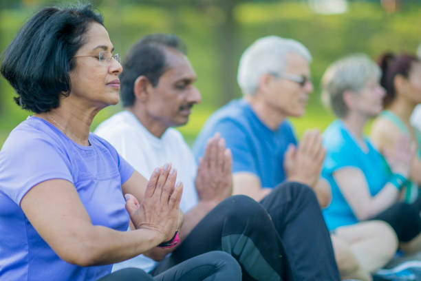 Senior Group Meditating in the Park