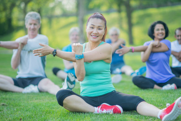istock Senior Woman Stretches With Group 801309780