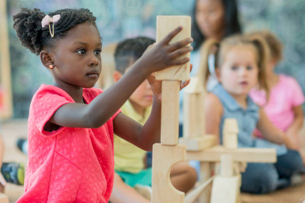 istock Girl Stacks Blocks at Preschool 801309980