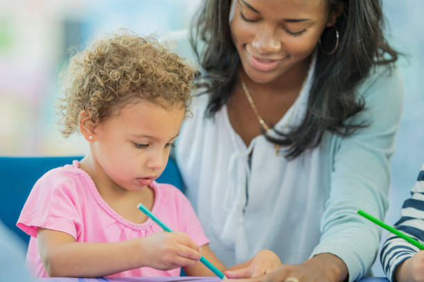 istock Teachers Helps Girl Color 801309996