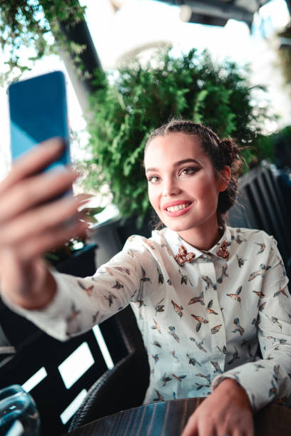 istock Smiling Beautiful Young Woman Making Selfie in a Cafe 801315866