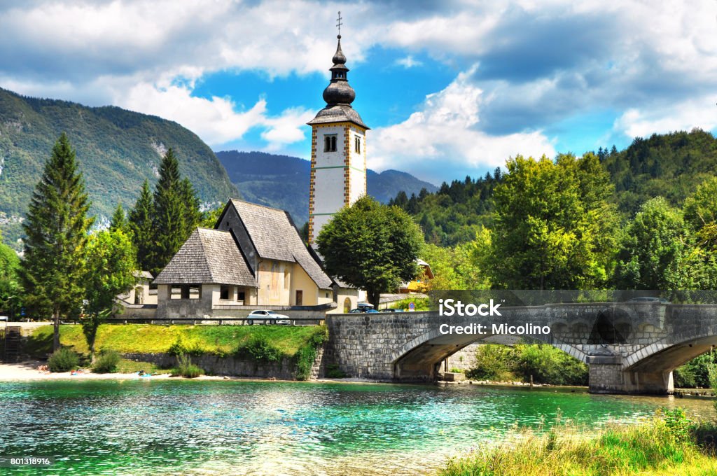 Bohinj Lake,Triglav National Park, Julian Alps, Slovenia. Bohinj Lake, Church of St John the Baptist with bridge. Triglav National Park, Julian Alps, Slovenia. Slovenia Stock Photo
