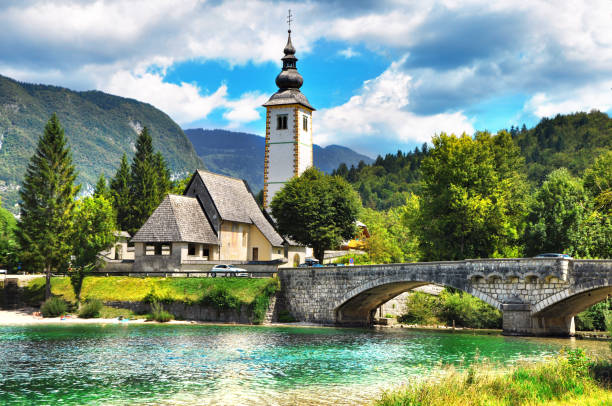 Bohinj Lake,Triglav National Park, Julian Alps, Slovenia. Bohinj Lake, Church of St John the Baptist with bridge. Triglav National Park, Julian Alps, Slovenia. julian alps stock pictures, royalty-free photos & images