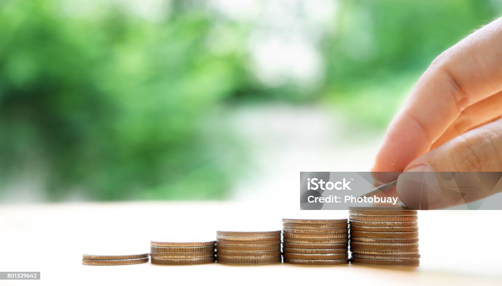 Close up of female hand stacking coins Abundance Stock Photo