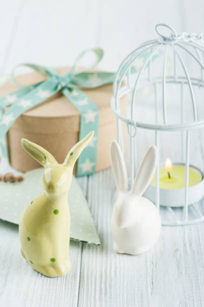 istock Mint green lit candle in white lantern with gift 801341340