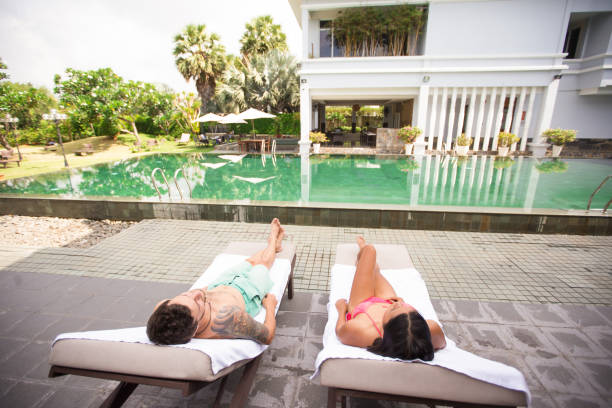 istock Couple Relaxing on Chaise Longues Near Pool 801342996