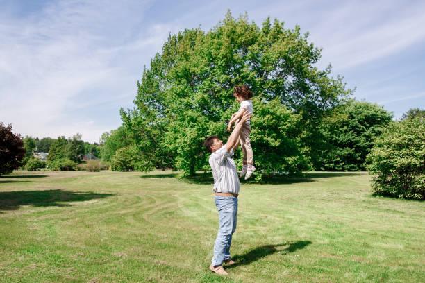 istock Dad plays with his daughter throws her up and catches. 801344032
