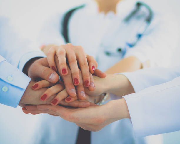 istock Doctors and nurses in a medical team stacking hands 801349896