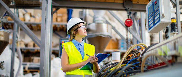 junge frau, die arbeit in fabrik als qualitätskontrolleur - quality control safety factory industry stock-fotos und bilder