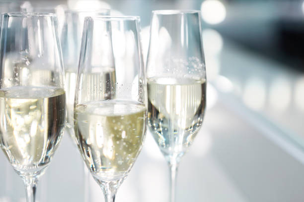 bicchieri champagne su sfondo bianco a luci brillanti - prosecco foto e immagini stock