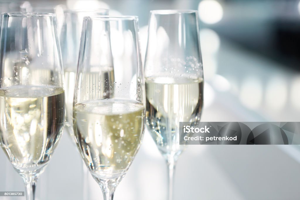Champagne glasses on white background in bright lights Champagne glasses on white background in bright lights. Fashion show backstage Prosecco Stock Photo