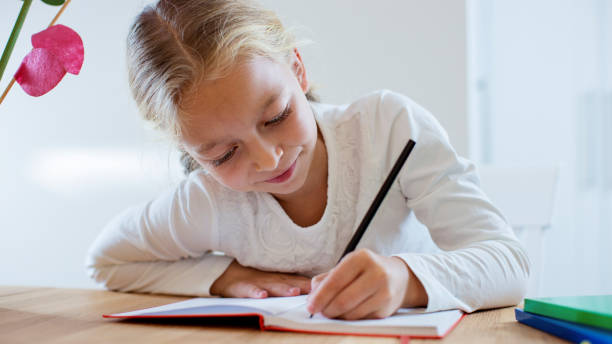 istock Satisfied little girl doing homework 801385742