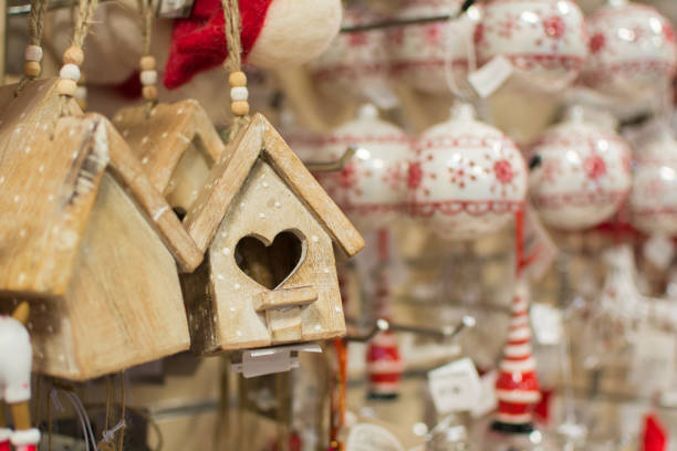 Hanging Christmas decoration in the shop with tags, with blurred baubles on the back, selective focus
