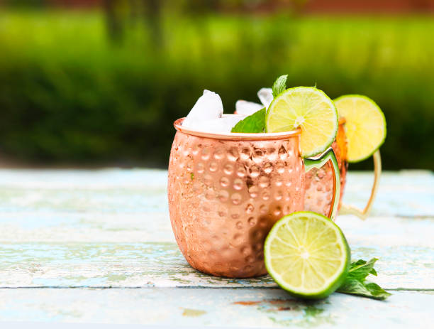 istock Natural homemade lemonade in cooper mugs on rustic wooden background 801386216