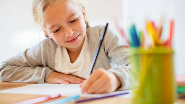 istock Smiling school girl doing homework 801388666