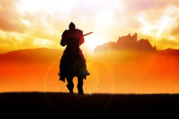 Silhouette of a medieval knight on horse carrying a lance on dramatic scene