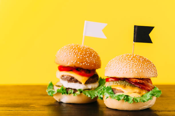 istock Bright juicy appetizing burgers with chops, cheese, marinated cucumbers, tomatoes and bacon 801417396