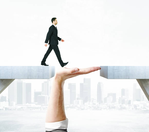 Support concept Businessman crossing abstract hand bridge on city background. Support concept bridge hand stock pictures, royalty-free photos & images