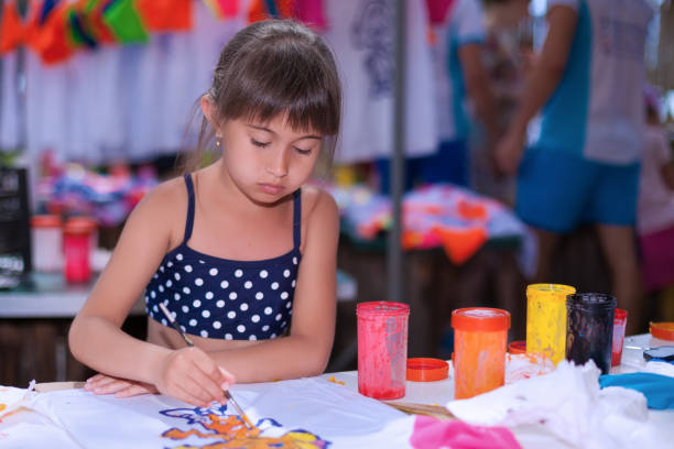 istock Little girl is drawing with paints outdoors 801435310