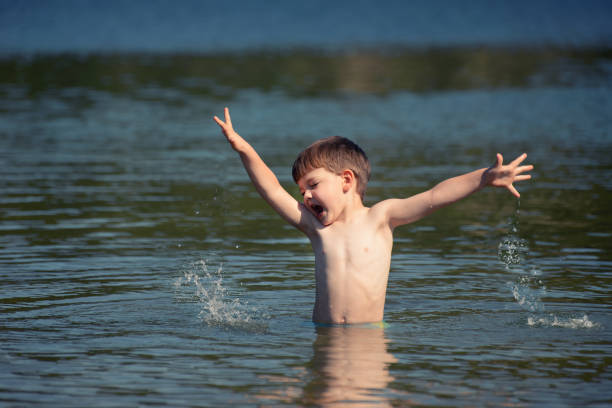 istock Happy boy playing in the lake in the hot summer 801444418