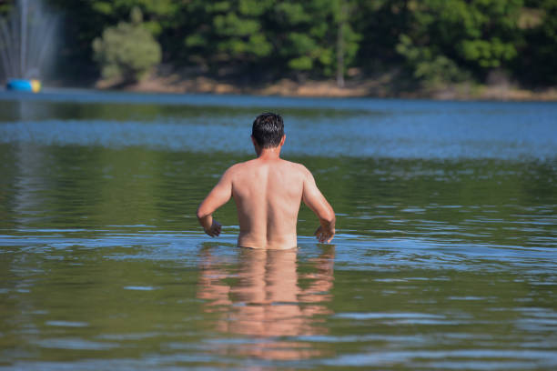 istock Attractive young man swiming in the lake 801447222