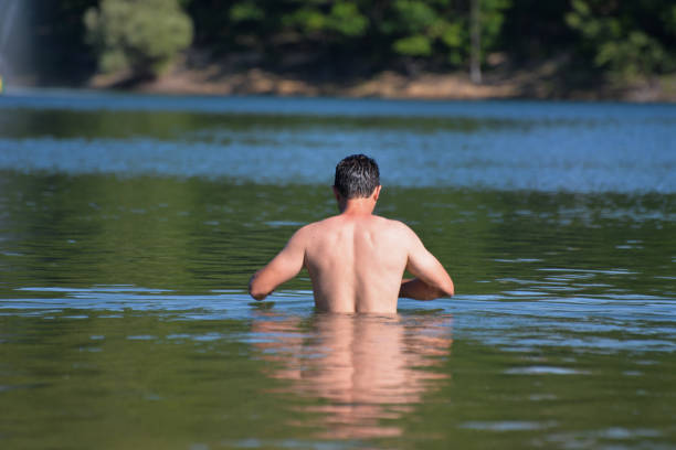 istock Attractive young man swiming in the lake 801460192