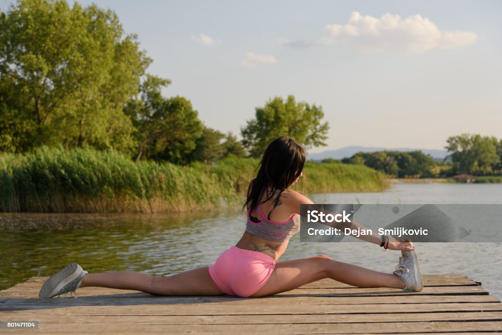 Teenage performs a gymnastic exercise star Teenage exercise gymnastics on the dock next to the lake Active Lifestyle Stock Photo
